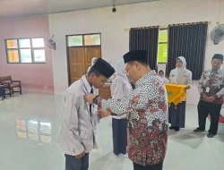 Foto: Kepala MTsN 1 Pati, Wahyu Hidayat kalungkan secara simbolis tanda peserta Latihan Dasar Kepemimpinan Siswa (LDKS) tahun 2025.(Portalljateng/MTsN 1 Pati)