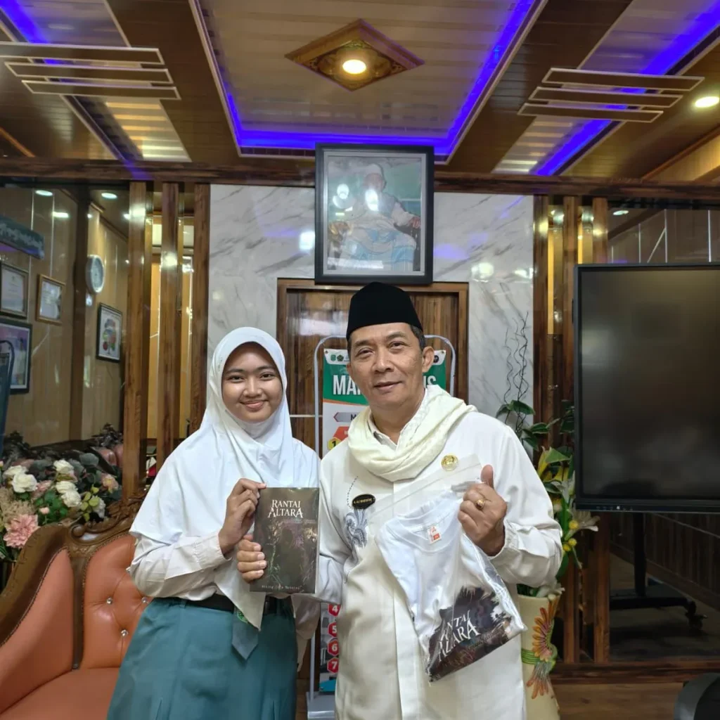 Foto: Kepala MAN 2 Kudus, Ali Musyafak dan Bening Cita Maharsi, siswa kelas XI-11 Jurusan IPS.(Portalljateng/MAN 2 Kudus)