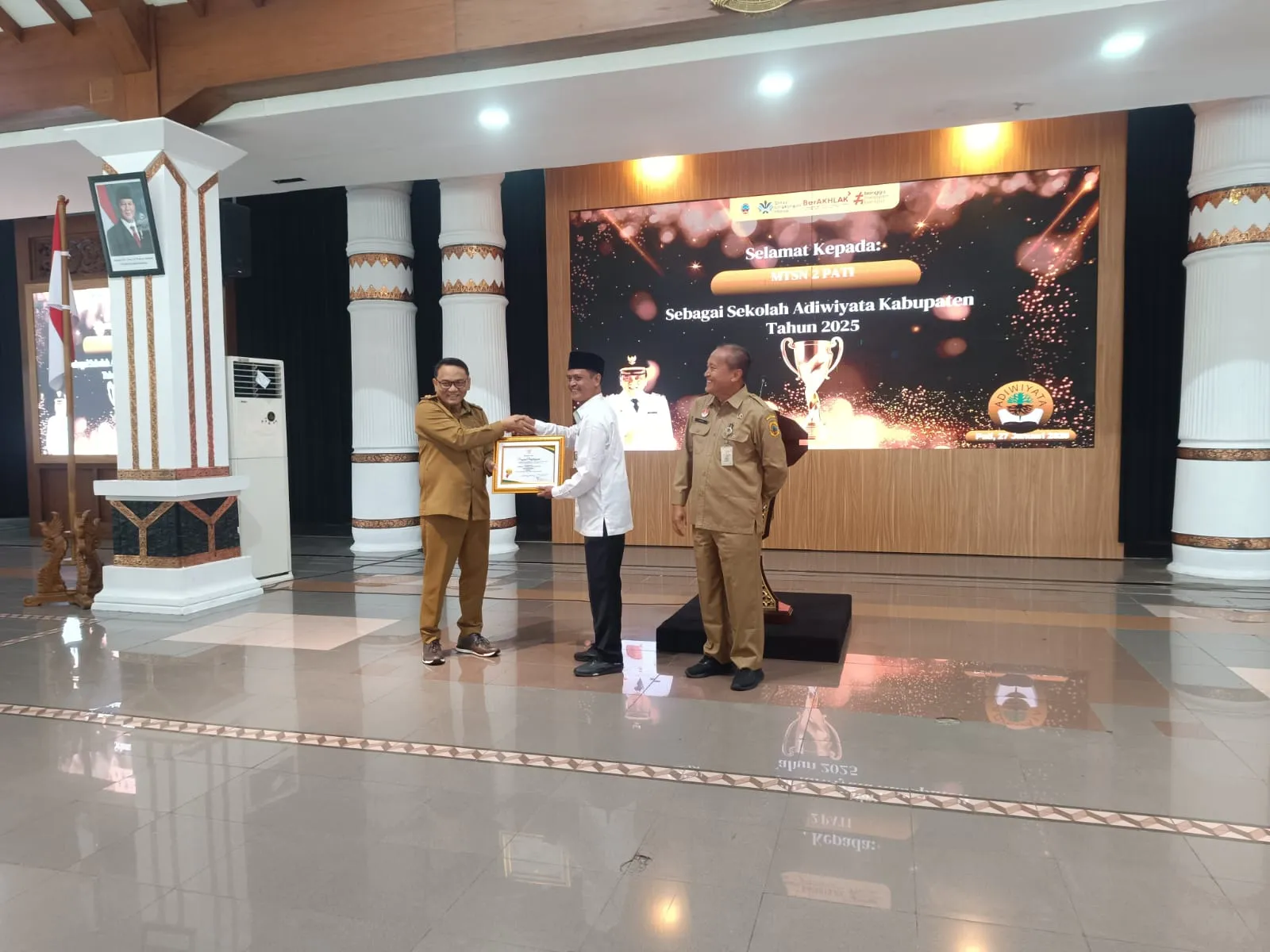 Foto: Penyerahan penghargaan Adiwiyata tingkat Kabupaten Pati, Plt. Bupati Pati Risma Ardhi Chandra kepada Kepala MTsN 2 Pati Zaenal Arifin di Pendopo Kabupaten Pati.(Portalljateng/Adm)